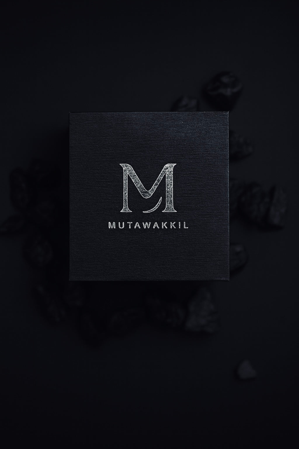 Luxury black Mutawakkil jewelry box with silver embossed logo on dark background.