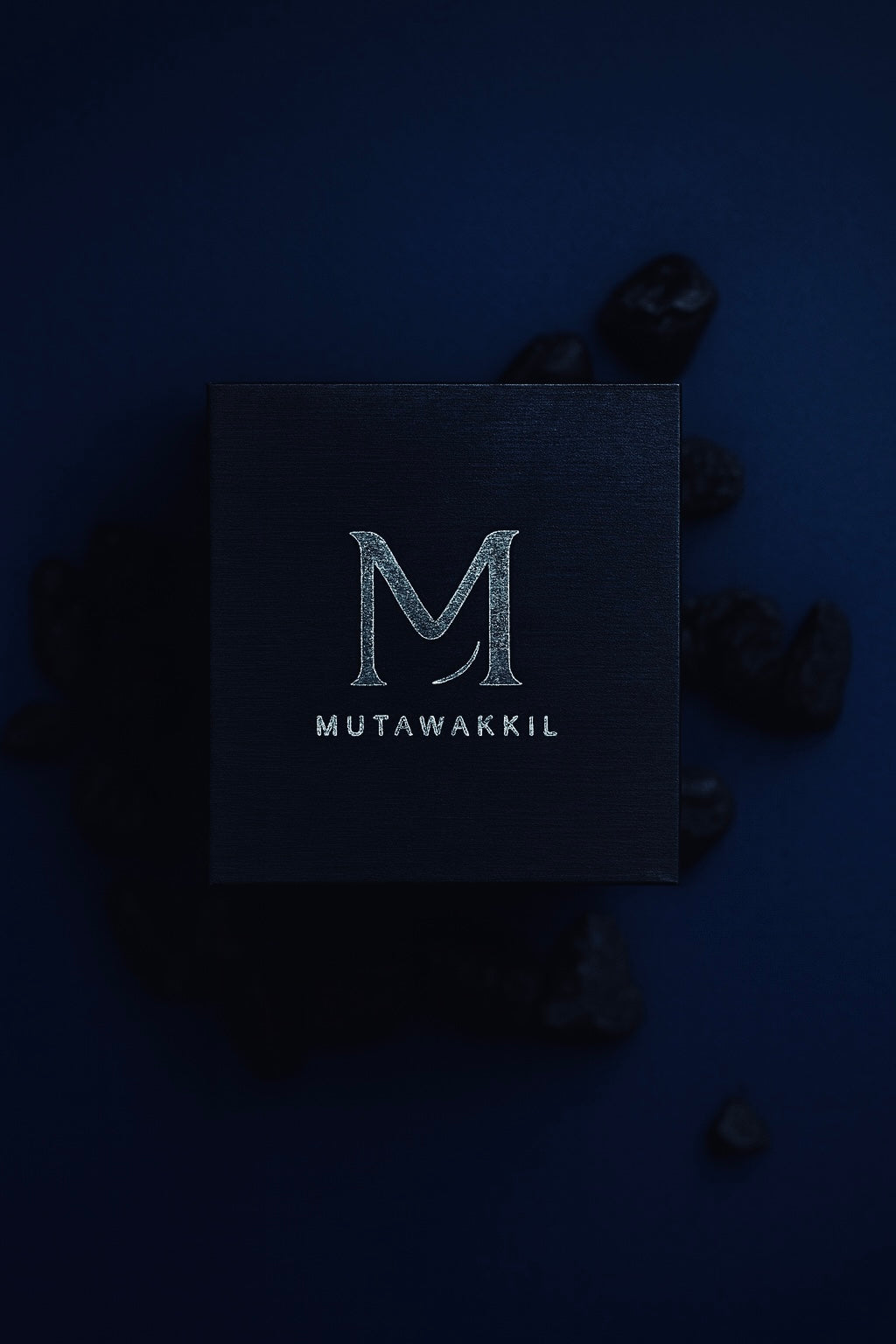 Luxury black Mutawakkil jewelry box with silver embossed logo on deep blue background.